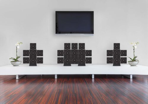 Commercial product photography of speakers placed on a table with TV & wooden floor
