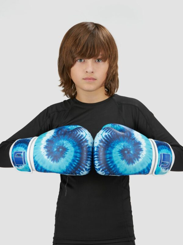 Action photography of a child model wearing sea green tie and dye boxing gloves