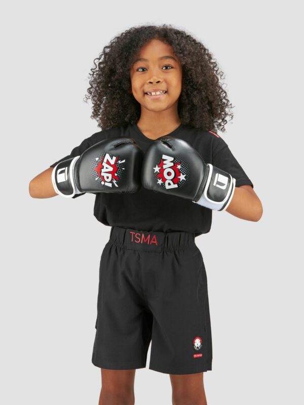 Action photography of a black female child model with curly hairs wearing boxing gloves and tigear sport suit