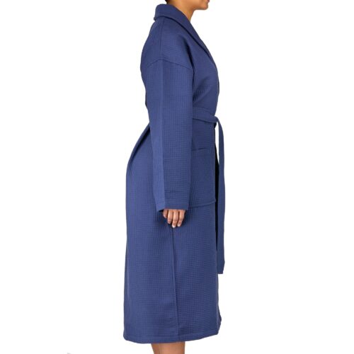 Clothing photoshoot side shot of a female model wearing a blue colored bath robe on a white background.