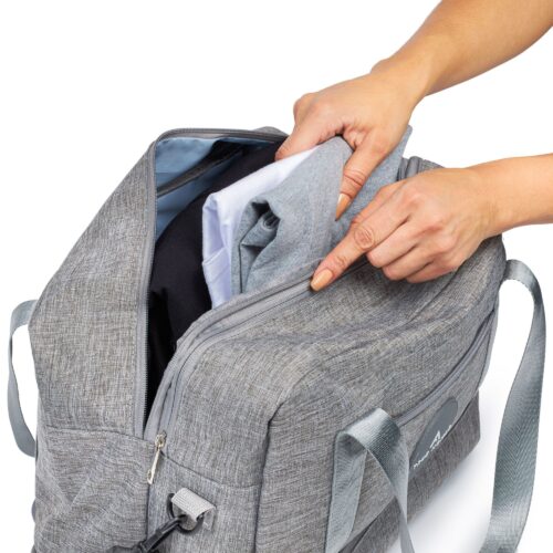 White background action shot of a female hand model putting clothes inside a travel bag by Isa Aydin NJ NY LA