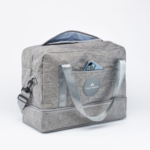 Action shot of a travel bag with open zip and an iPhone in Sierra blue color placed in the side pocket shot on a white background by Isa Aydin NJ NY LA