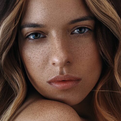 Beauty portrait of a white female model with freckles on her face shot by commercial photographer Isa Aydin.